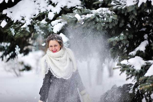 Красивая девушка зимой бросает снег | Премиум Фото