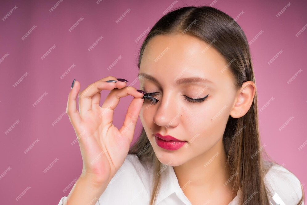 Premium Photo Beautiful Girl Tries On False Eyelashes On A Pink