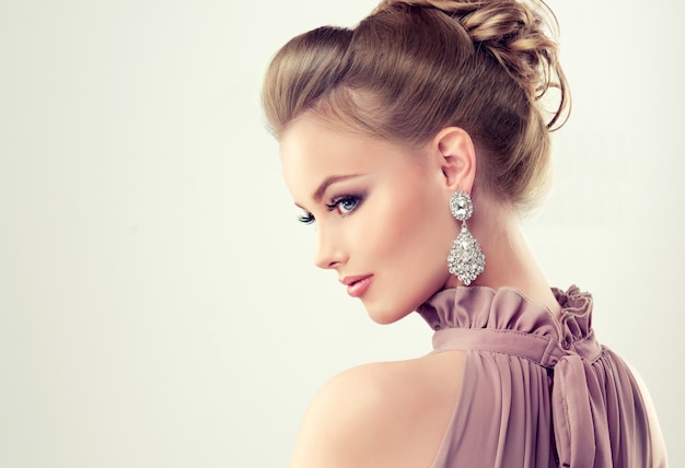 Beautiful girl with elegant hairstyle and big earrings jewelry Premium Photo
