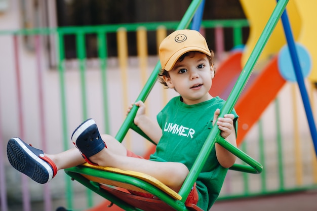 Premium Photo | Beautiful little boy spinning on a summer swing with ...