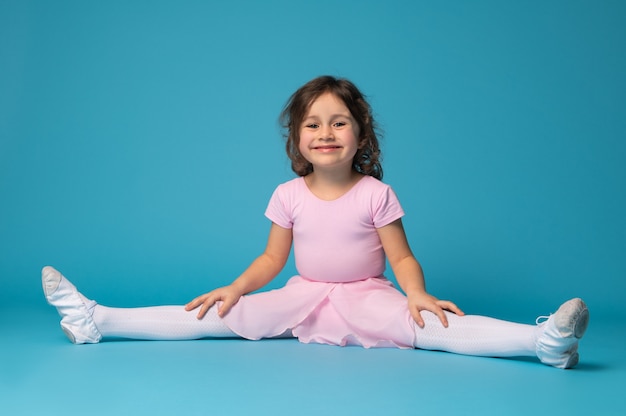 Premium Photo | Beautiful little girl ballerina sitting, practices ...