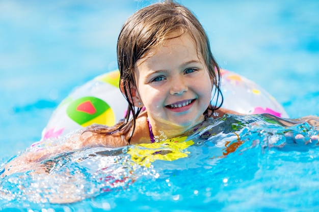 Premium Photo | Beautiful little girl swimming at the pool