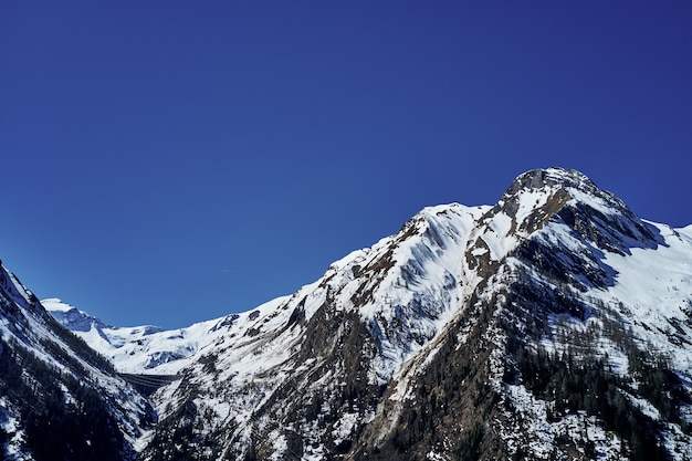 Bello Colpo Di Angolo Basso Di Una Montagna Con Neve Che Copre Il Picco E Il Cielo Nei Precedenti Foto Gratis