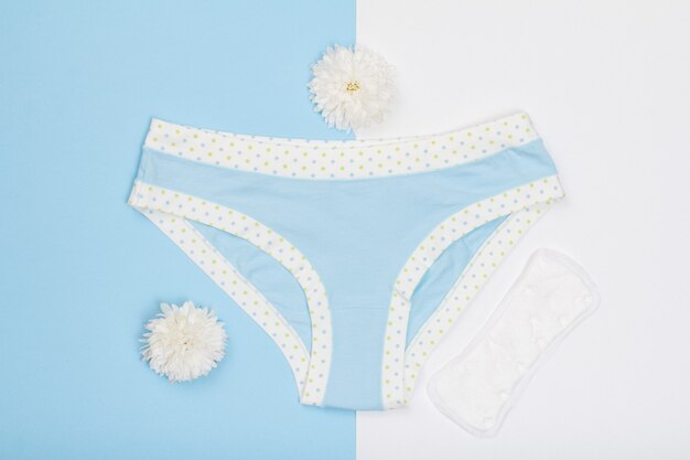 Premium Photo Beautiful Panties With Sanitary Napkin And Flower Buds On Blue And White