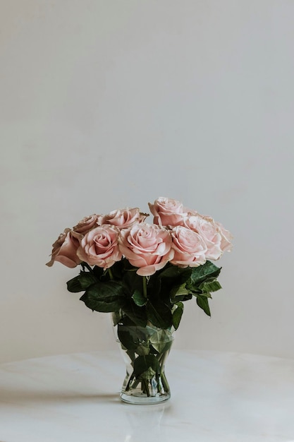 Premium Photo | Beautiful pink roses in a vase on a table