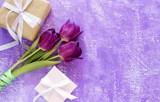 紫色の背景に美しい紫色のチューリップの花束とギフトボックス 春の花のチューリップの背景 プレミアム写真