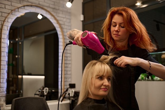 Premium Photo | Beautiful red-haired woman professional hairdresser ...