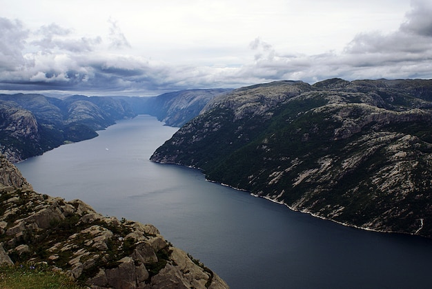 スタヴァンゲル ノルウェーの曇り空の下で湖の近くの有名なpreikestolen崖の美しい風景 無料の写真