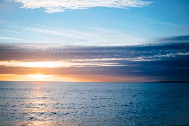 穏やかな海に沈む夕日の美しい風景 無料の写真