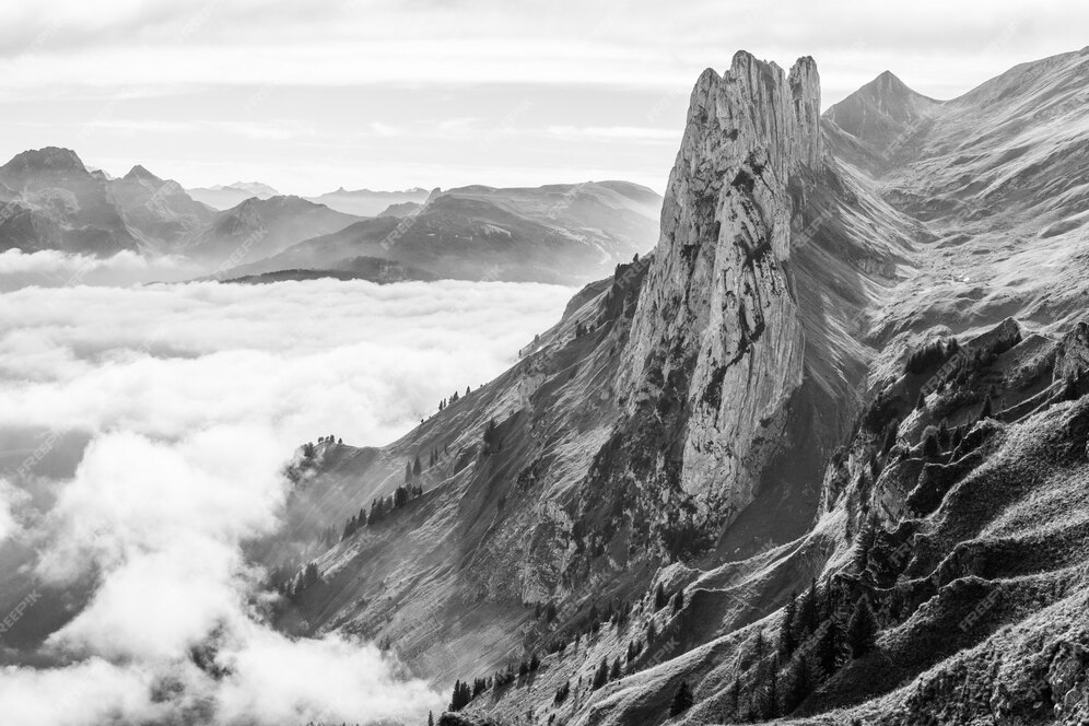 Free Photo | Beautiful shot of a mountain above the clouds in black and ...