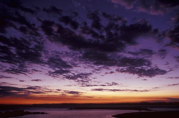 Free Photo Beautiful Shot Of A Purple Sky With Clouds Above The Sea At Sunset