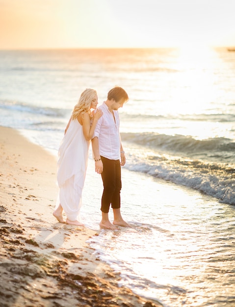 Free Photo | Beautiful stylish couple posing on the beach