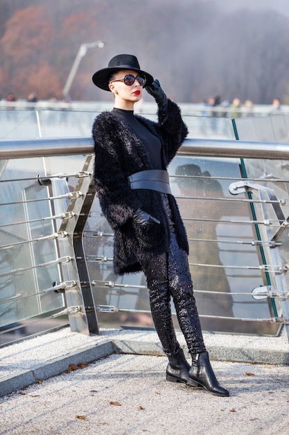 Premium Photo | Beautiful stylish woman in a black hat on glass bridge