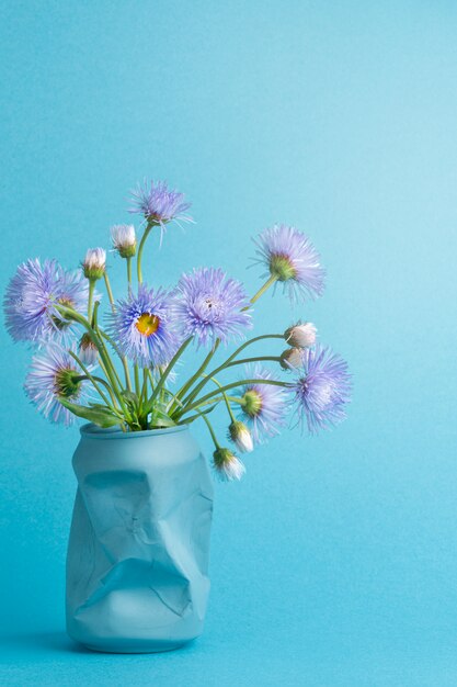 花瓶の代わりにソーダの缶に紫色のヒナギクの花の美しい夏の春の花束 プレミアム写真