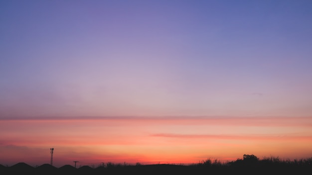 劇的な概念の美しい夕日の風景の背景 青とオレンジのグラデーションで澄んだ空のトーンとシルエットの街 プレミアム写真