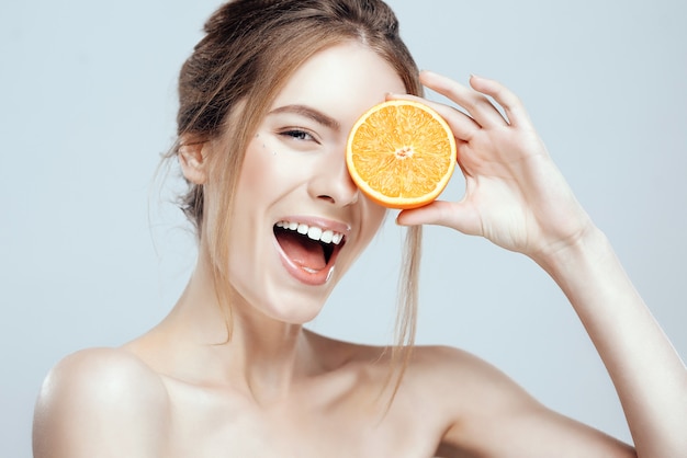 Premium Photo | Beautiful woman face with juicy orange