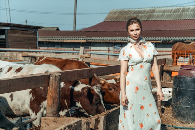 Premium Photo A Beautiful Woman On A Farm Feeds The Cattle With Hay