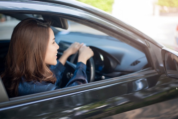 美しい女性は彼女の車を運転しています プレミアム写真