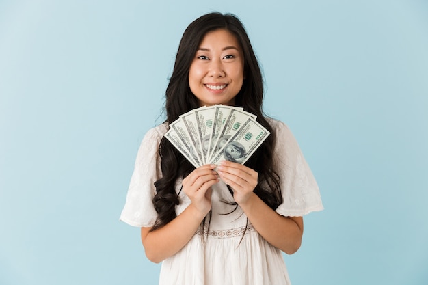 Premium Photo | Beautiful woman isolated over blue wall holding money