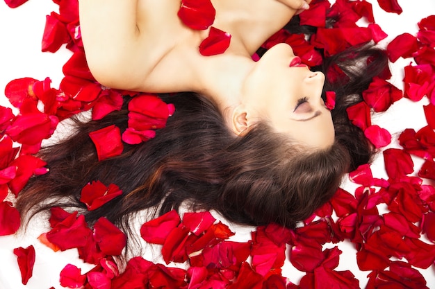 Premium Photo Beautiful Woman In Petals Of Red Roses Over White