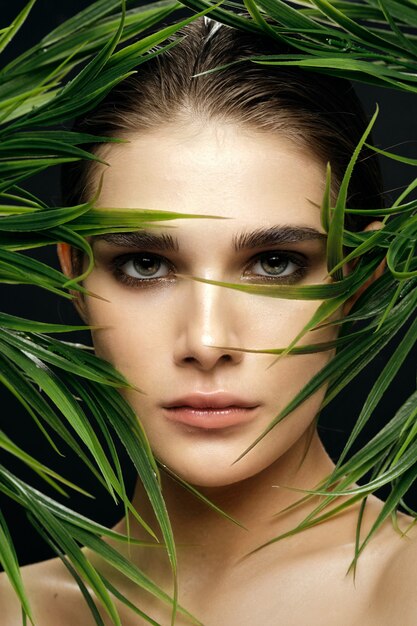 Beautiful woman portrait in palm bushes, beautiful skin of the face Premium Photo
