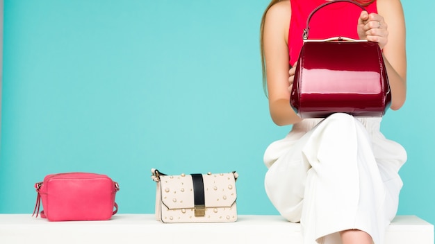 Premium Photo | Beautiful woman sitting on the bench with three handbag ...