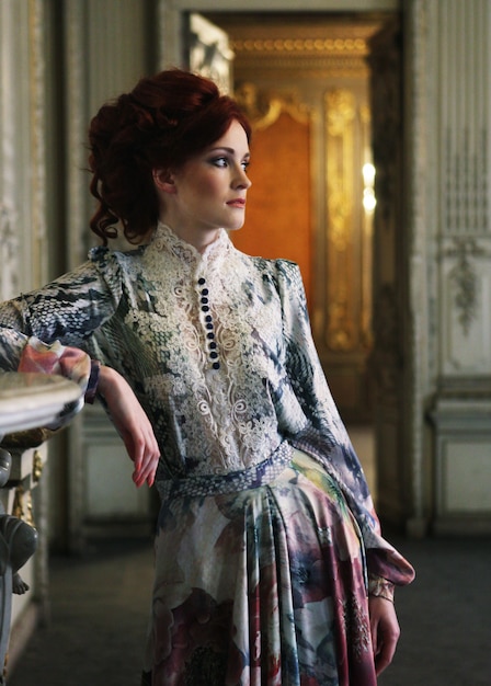 Beautiful woman standing in the palace room. | Premium Photo