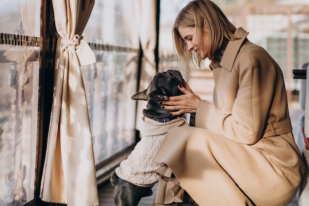 Free Photo | Beautiful woman with her cute french bulldog in warm outfit