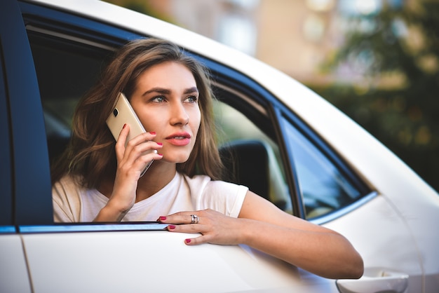 Premium Photo | Beautiful woman with phone smiling while sitting on the ...