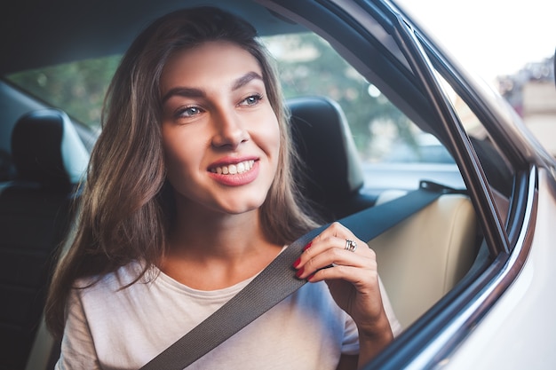 Premium Photo Beautiful Woman With Phone Smiling While Sitting On The Back Seat In The Car
