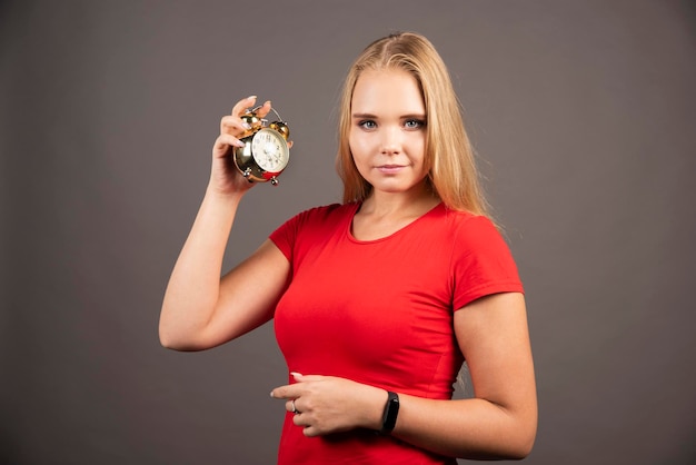 Free Photo Beautiful Woman With Small Clock Standing On Dark Background High Quality Photo