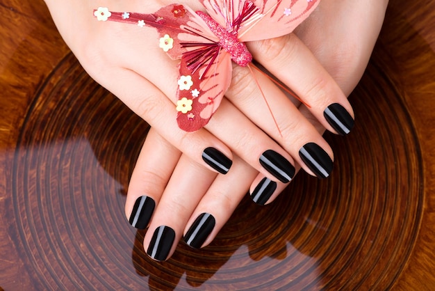 Beautiful women hands with black manicure after spa procedures - spa treatment concept Free Photo
