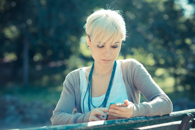 Beautiful Young Blonde Short Hair Hipster Woman Using Smart Phone