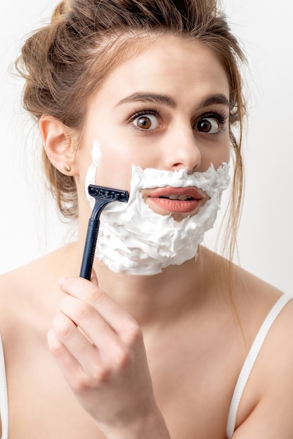 Premium Photo Beautiful Young Caucasian Woman Shaving Her Face By Razor On White Wall Pretty 9631