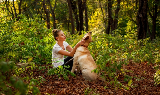 Premium Photo | Beautiful young girl sitting in the forest with a dog ...