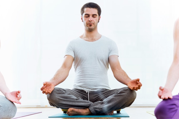 Premium Photo | Beautiful young man practicing yoga at home. sukhasana ...