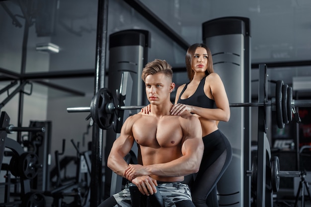 Premium Photo | Beautiful young sporty sexy couple showing muscle and  workout in gym during photoshooting
