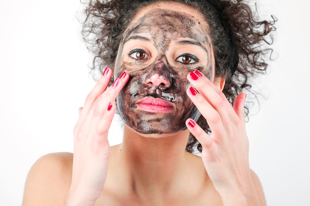 Woman applying charcoal face masks. | Photo: Freepik