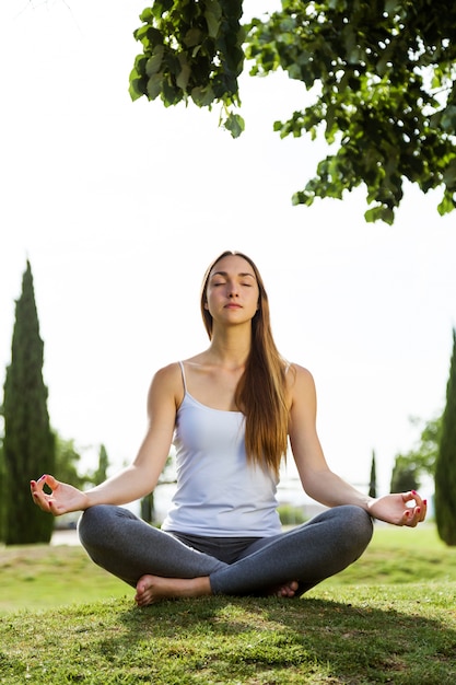 Free Photo Beautiful young woman doing yoga in the street.