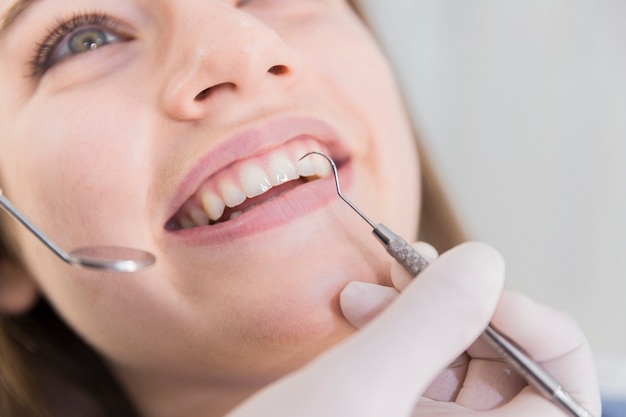 Beautiful young woman having dental check up Free Photo