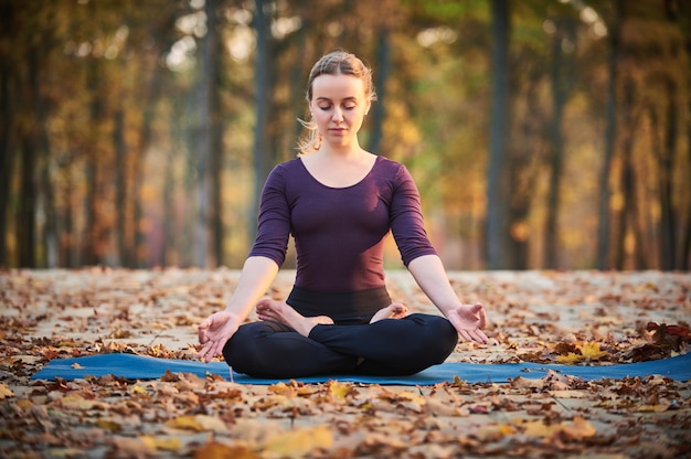 Premium Photo | Beautiful young woman meditates in yoga asana padmasana ...