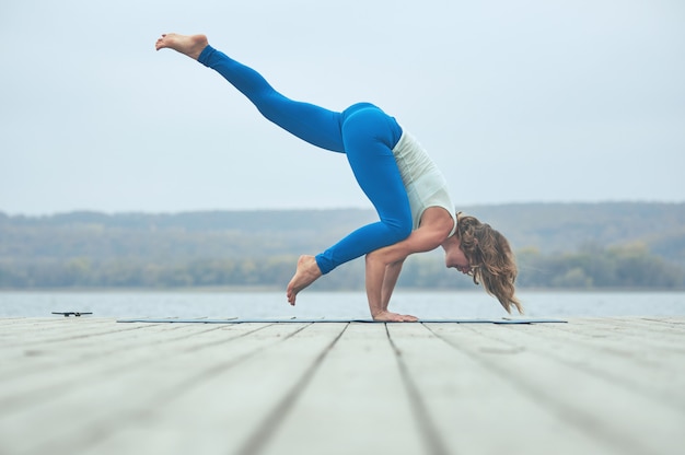 아름다운 젊은 여성 관행 요가 아사나 Eka Pada Bakasana | 프리미엄 사진