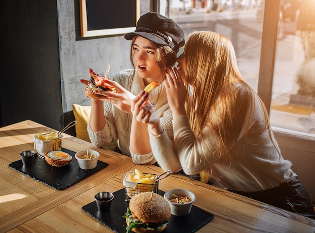 Premium Photo | Beautiful young women sit in side at table