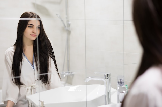 Free Photo | Beauty, hygiene, morning and people concept. smiling young  woman looking to mirror at home bathroom