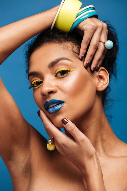 Free Photo Beauty Portrait Of Attractive African American Young Woman With Fashion Makeup And Accessories On Hands Posing Isolated Over Blue Wall