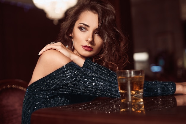 Premium Photo | Beauty young brunette woman sitting at the bar