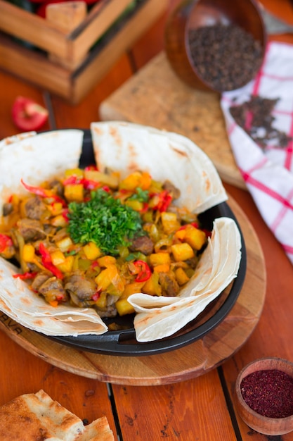 Beef meat stew with potatoes and chopped vegetables served with lavash Free Photo
