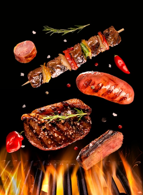 ビーフステーキ ソーセージ 串焼きの肉がグリルでグリルに落ちる ブラジルのバーベキュー プレミアム写真