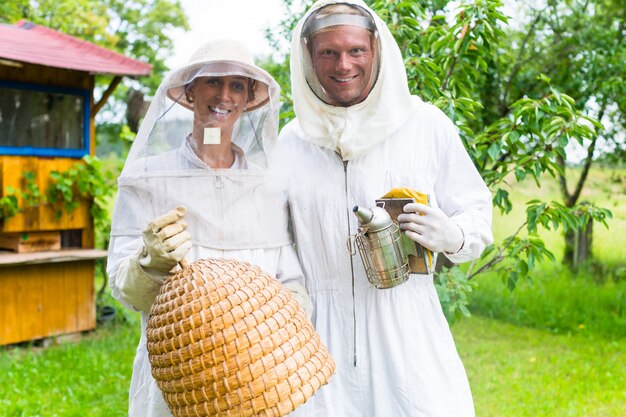 Premium Photo | Beekeeper team working outdoor with smoker and beehive