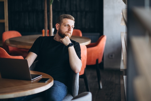 Beraded man working on laptop in a cafe Free Photo